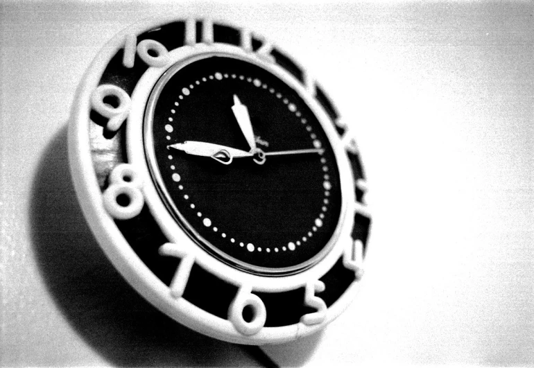 a black and white clock with a silver second hand