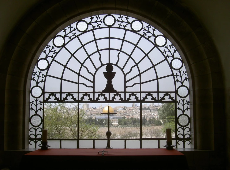 a church window with an arched glass and a candle in the center