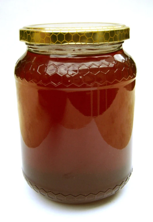 a jar of liquid with a yellow cap on the top