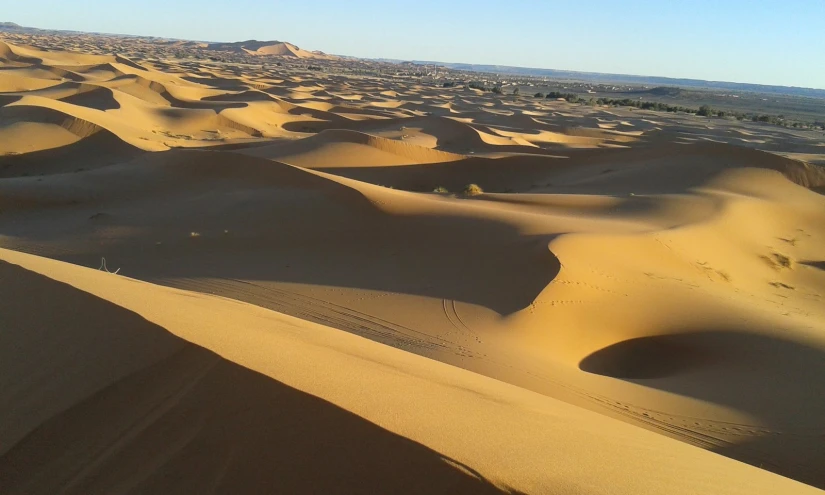 the view from top of a large sand dune at sunrise