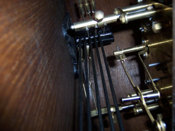 a close up of a wooden instrument with strings and an earbuds