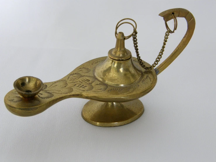 a ss teapot with a chain in the shape of a bell