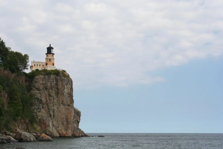 a large rock cliff extends into a vast body of water