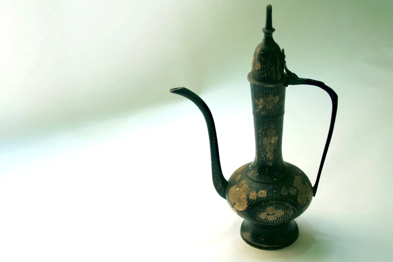 an old style oil can on display on a white background