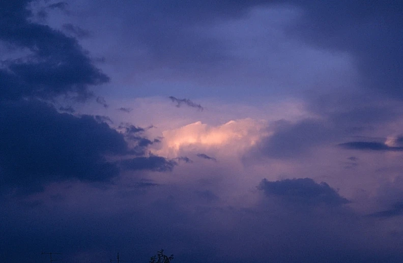 a large cloud is above the town lights