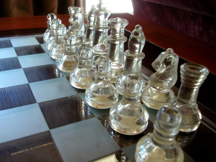 a group of glass chess pieces on top of a black table