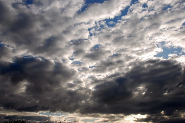 a blue sky filled with clouds and trees