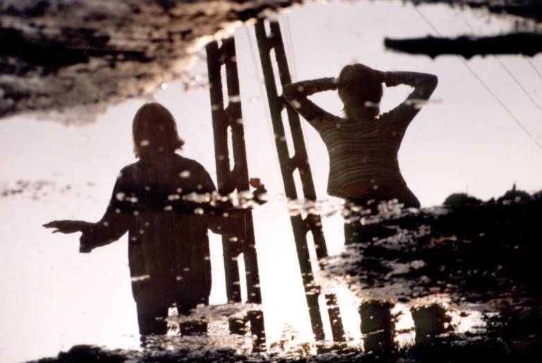 two reflection of two women standing next to each other