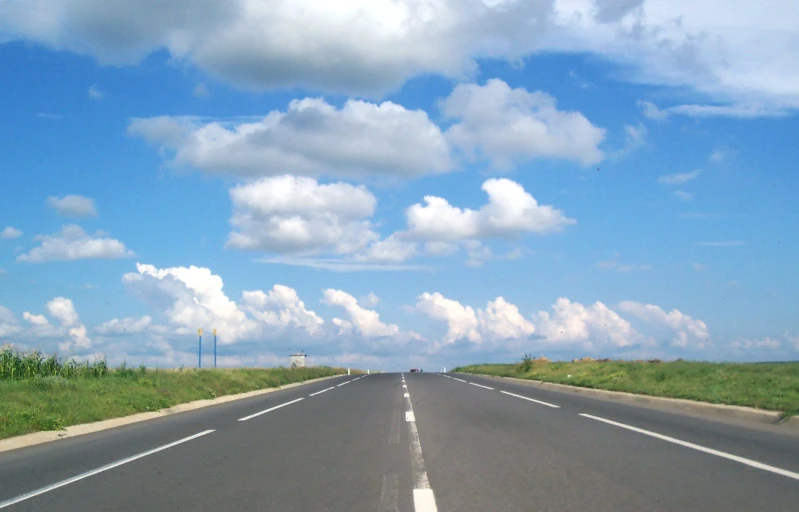 an empty road with a stop sign on the other side