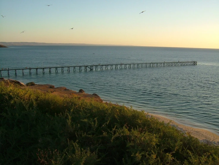 a long pier sitting out over the ocean