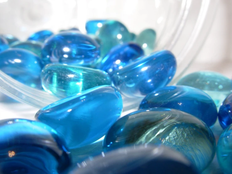 close up of a lot of glass marbles in blue