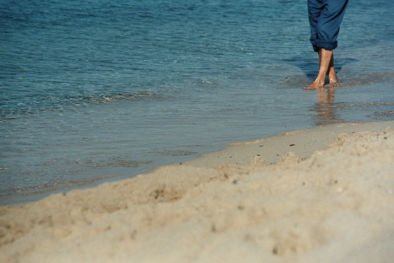 a person walking on the sand at the beach