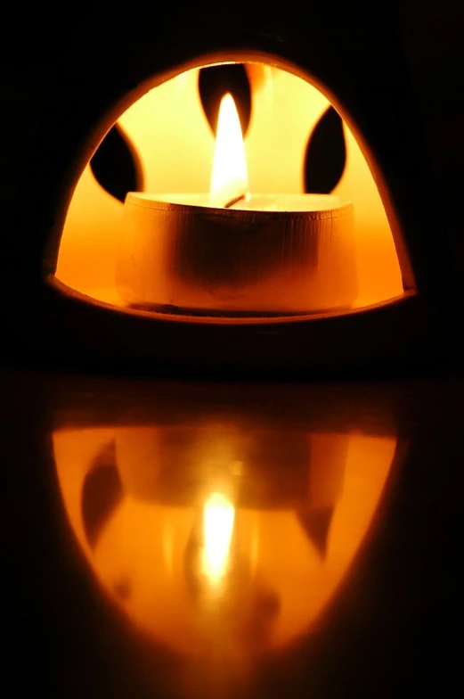 a burning candle in an oven lit with its bright flame