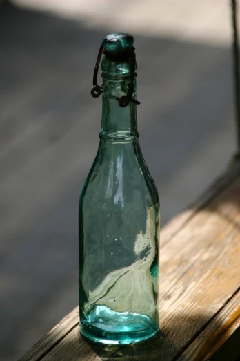 a green bottle sitting on top of a wooden table