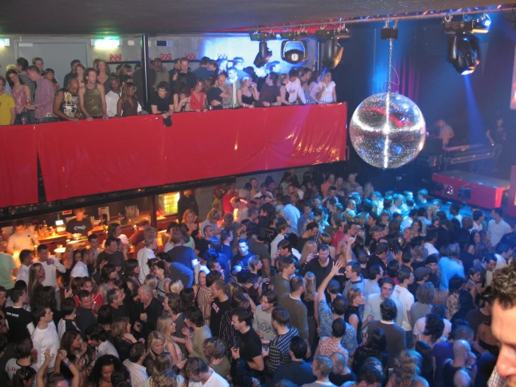 a large group of people are dancing in a club