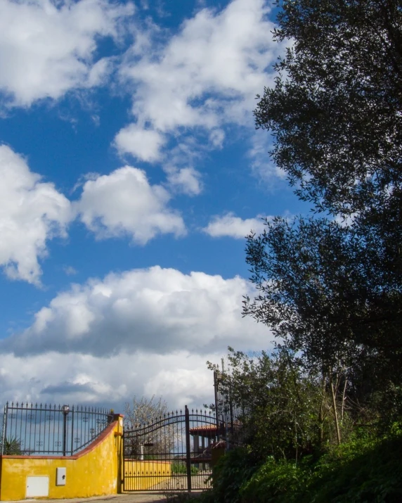 a building with a gate near by and trees