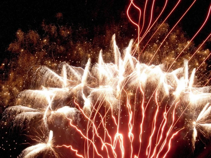 fireworks in the night sky, showing red and white smokes