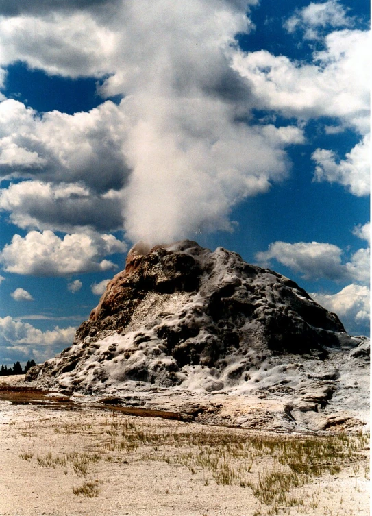 the desert is covered in large rocks and white clouds