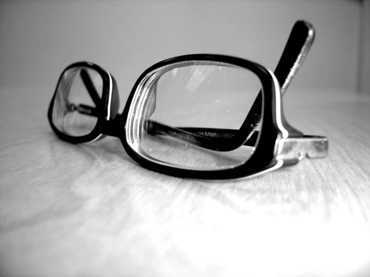 a pair of glasses sitting on top of a wooden table