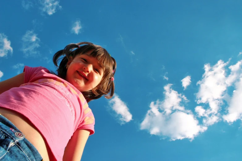 the girl is flying a kite high in the air