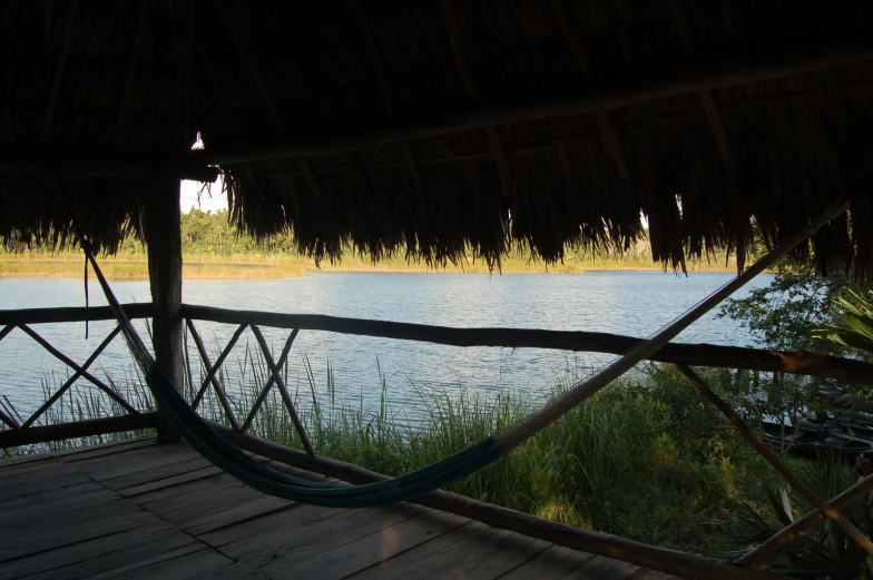 a small hammock sits on the deck of a wooden pier