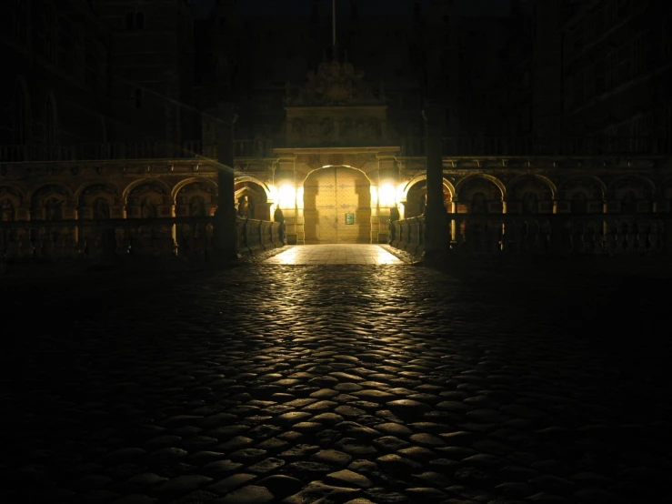 a walkway leading into an open cathedral with lit pillars