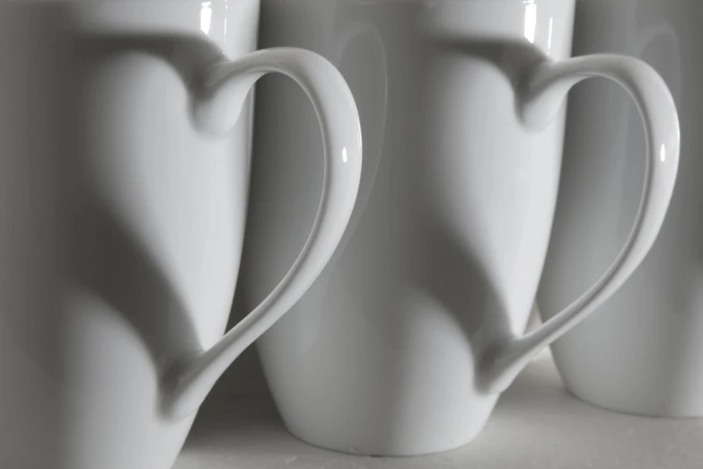 a close up of a row of white coffee cups