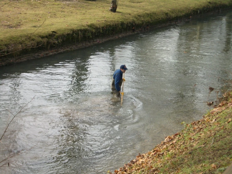 person walking along a river in the middle of the day