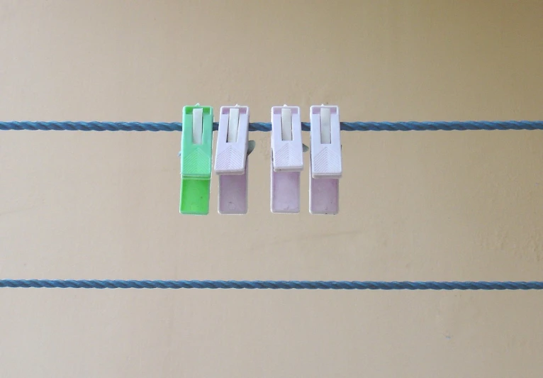 four little clothes clips hanging on a blue cable