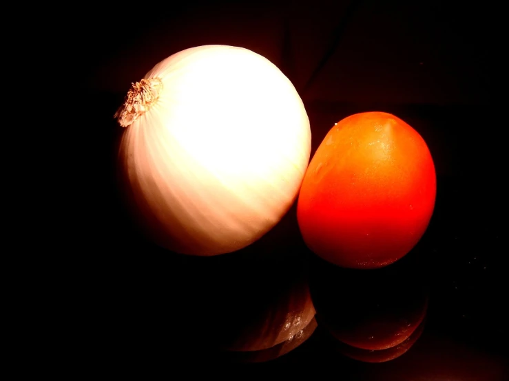 an onion and an orange on a black background