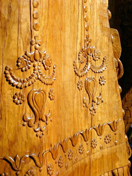 ornate designs are on the wood of this old wooden door