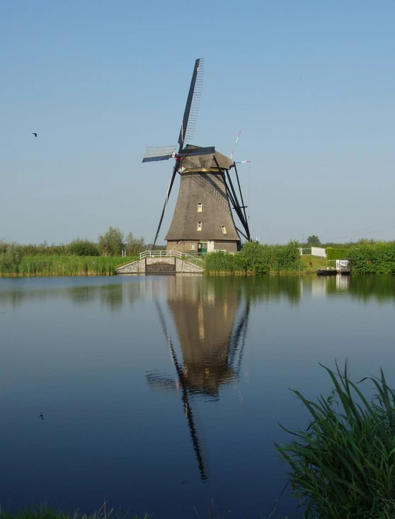 a windmill is reflected in the water