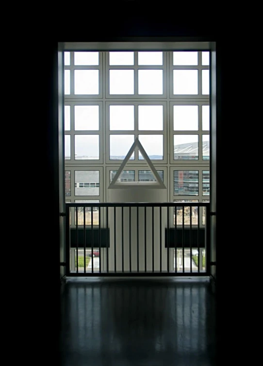 the open window shows city buildings and trees