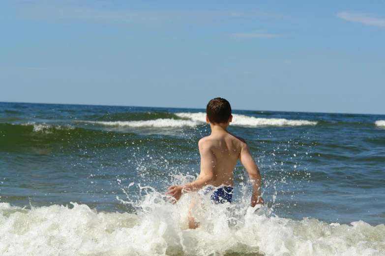 a boy wading in the ocean water