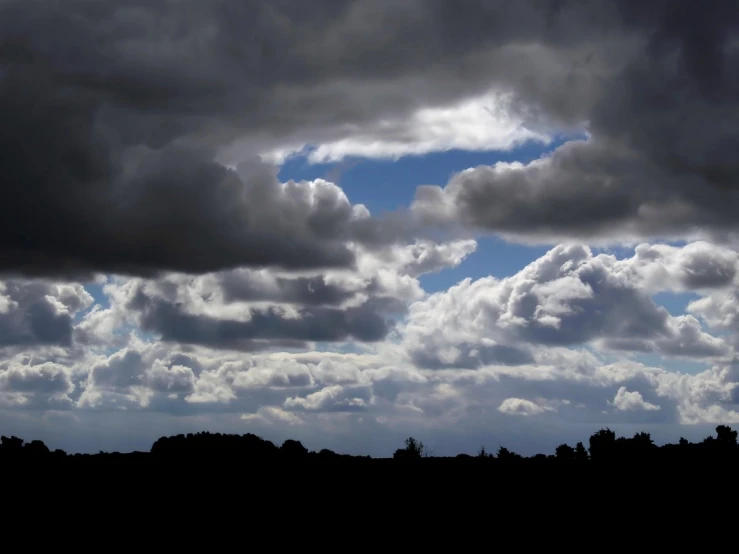 a large open field is shown with clouds over it