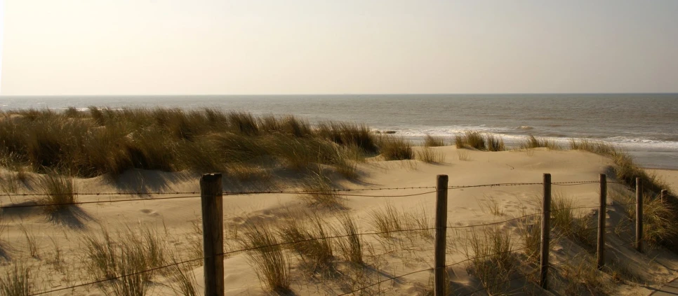 a fenced in area next to sand dunes