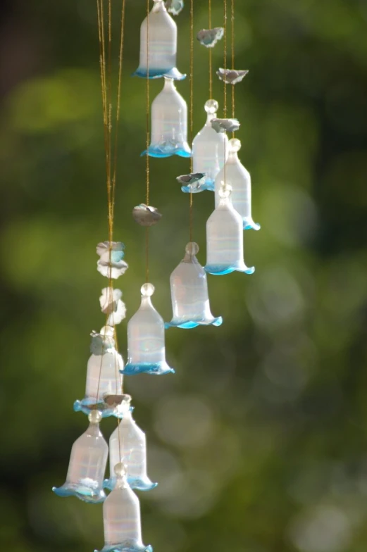 a bird sits on a wind chime outside