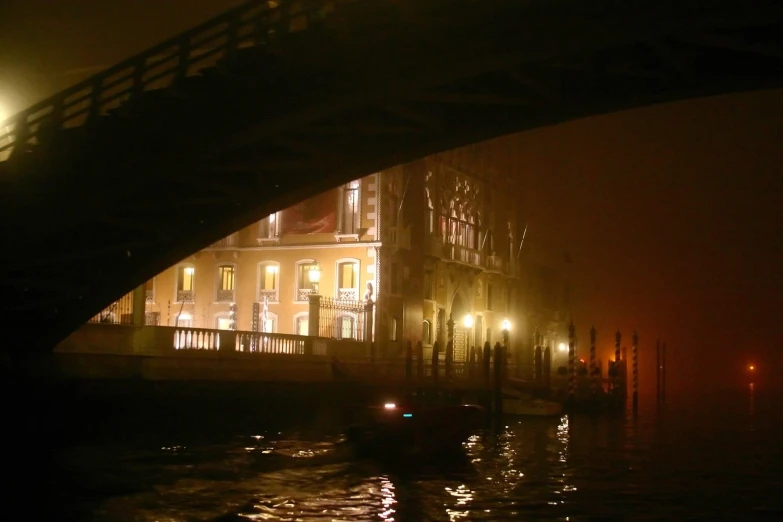 a bridge over water in front of some buildings