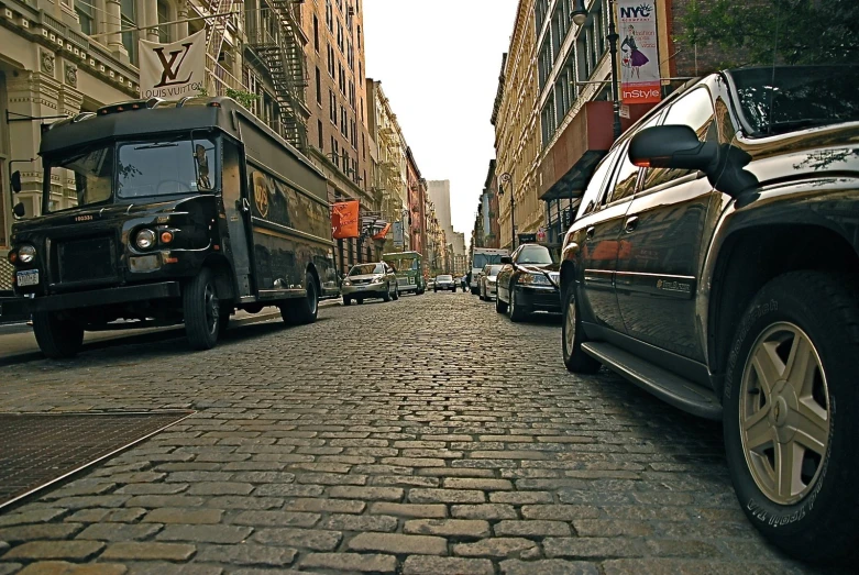 cars and trucks are on the street between buildings