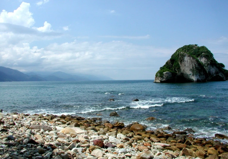 an ocean scene, with the water and mountains in the background