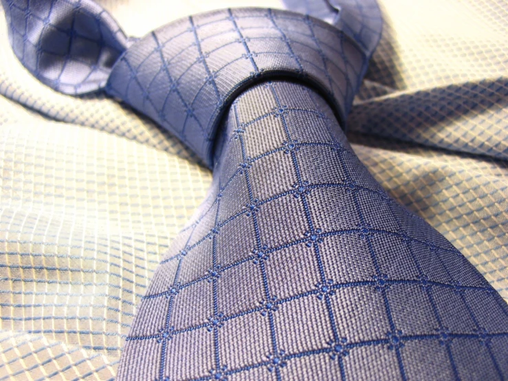 a close up view of a tie on a bed