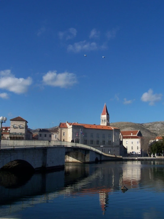 a stone bridge over a river that runs through a small town