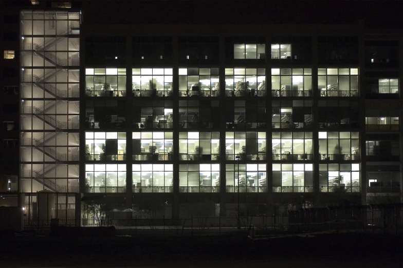 a building in the middle of the night, lit up with windows