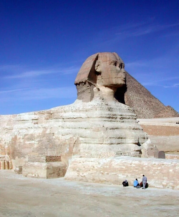 two people sitting near an egyptian monument