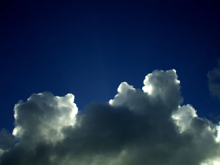 an airplane flying over dark clouds in the sky