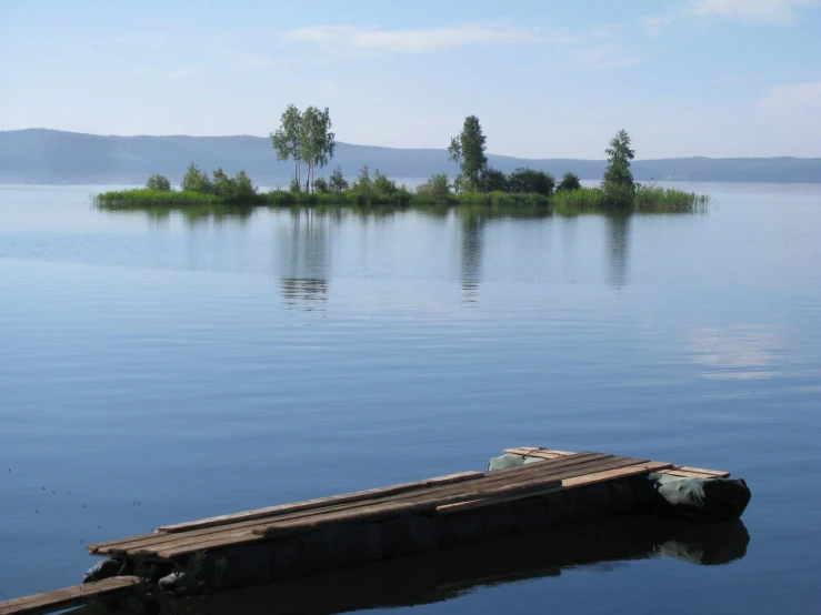 small boat sitting on the end of a large lake