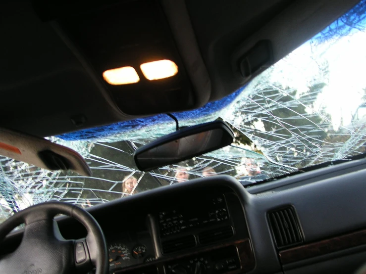 a broken windshield inside a car with no front door