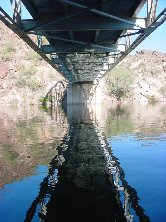 view of the underside of a bridge as it is surrounded by water