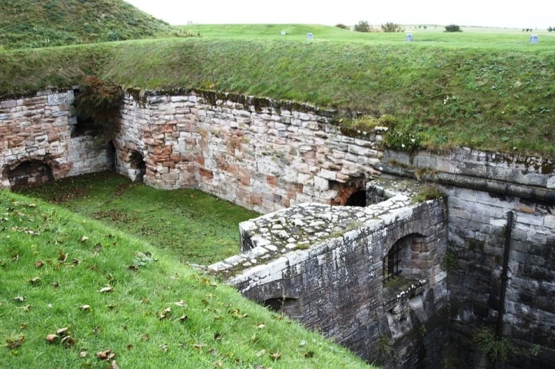 there is a very old concrete trench with a grass top