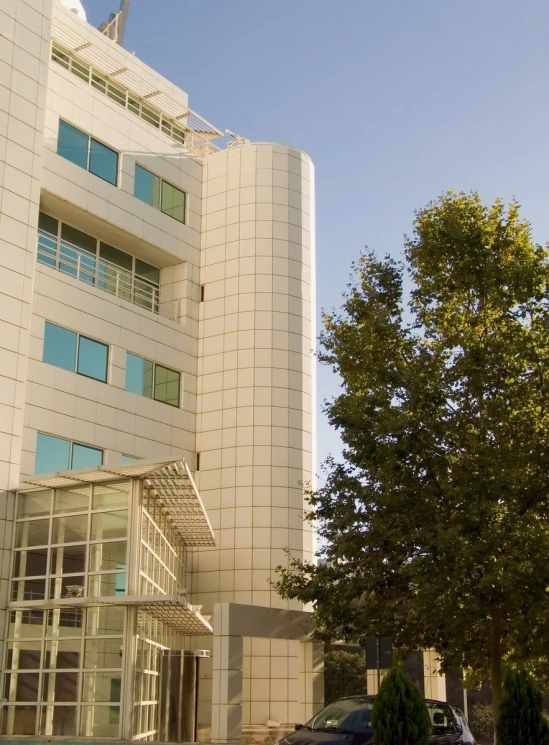 a tall white building with trees next to it